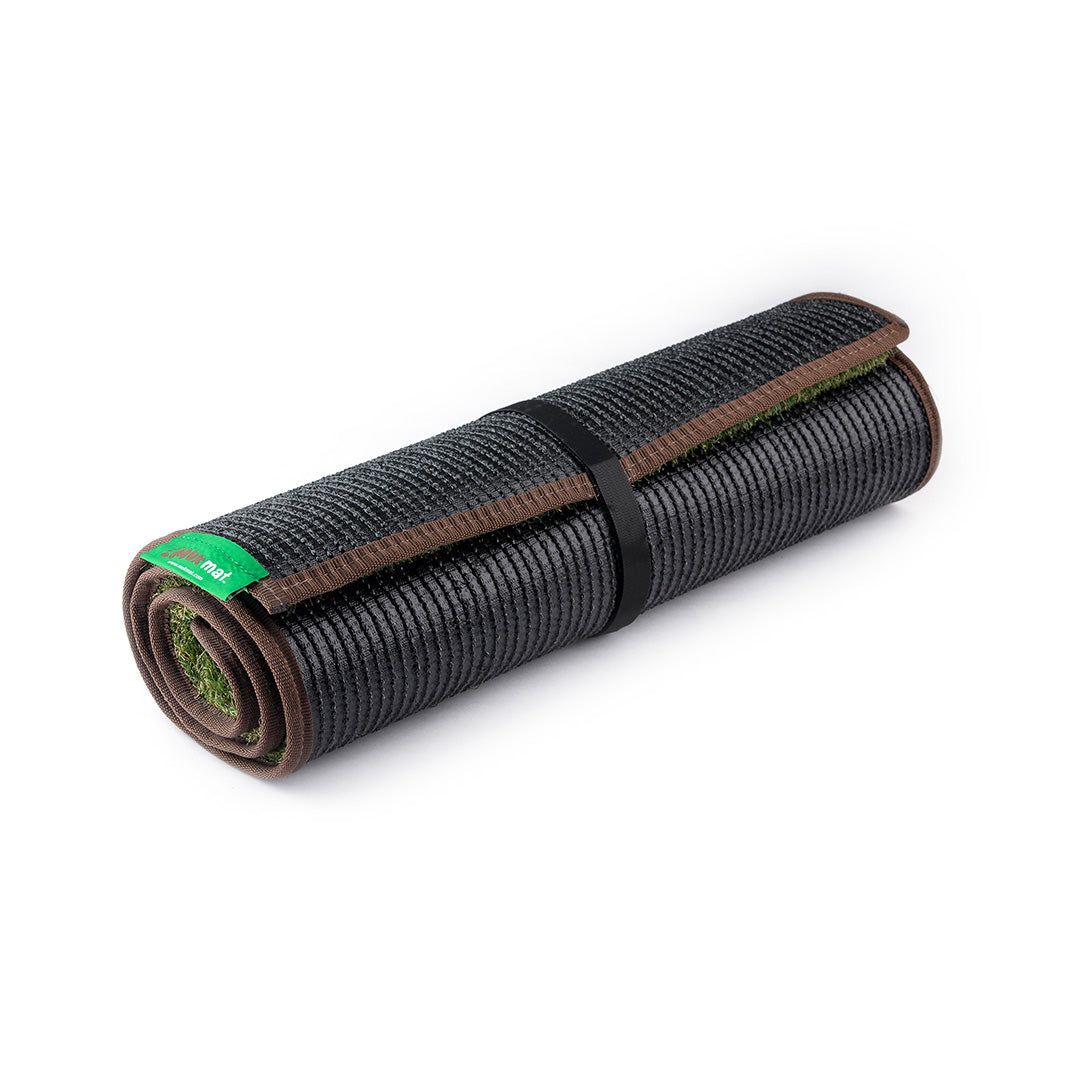 Extra large synthetic grass mat in Earth Brown trim rolled up and fastened with velcro strap.